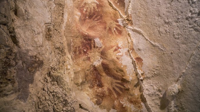 Hand outlines found on a cave wall in Indonesia are at least 39,900 years old, researchers said. Credit Kinez Riza